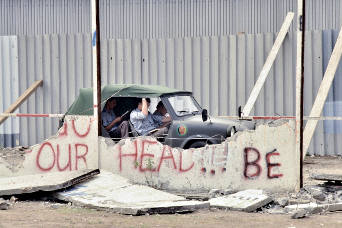 Berlin, 1990 – Kübelwagen Trabant mit Grenzsoldaten zwischen Resten der Hinterlandmauer (Fotograf: Detlef Gallinge)