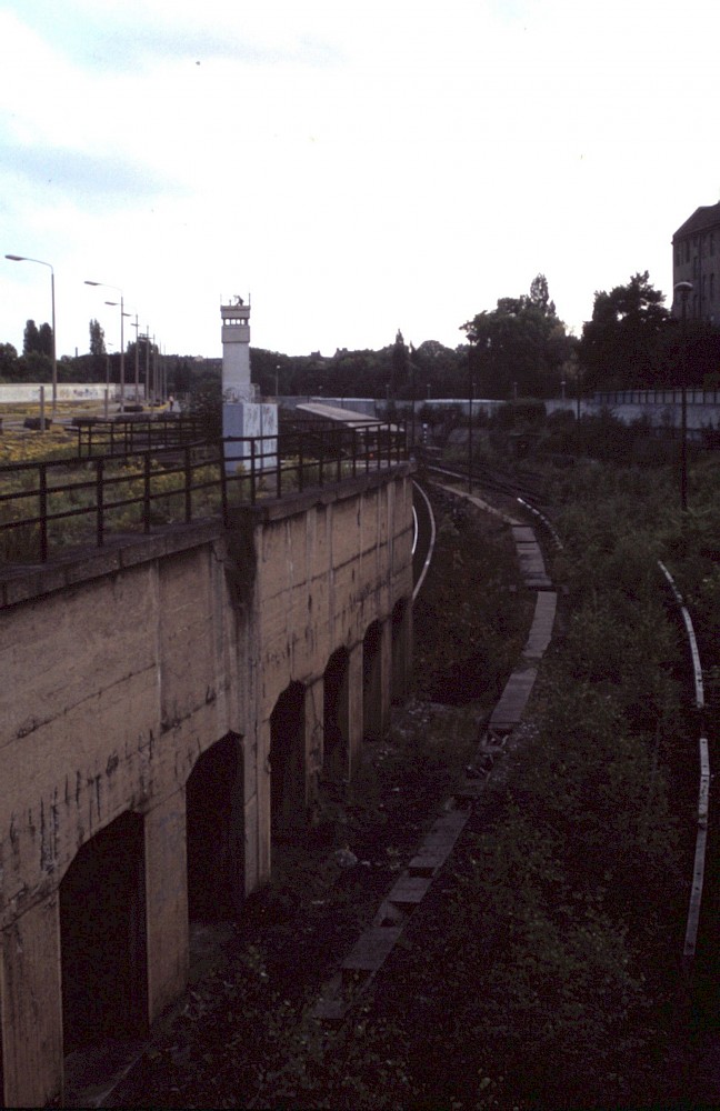 Berlin, 1990 – Grenzanlage und passierende S-Bahn auf dem Nordbahnhof-Gelände (Fotograf: )