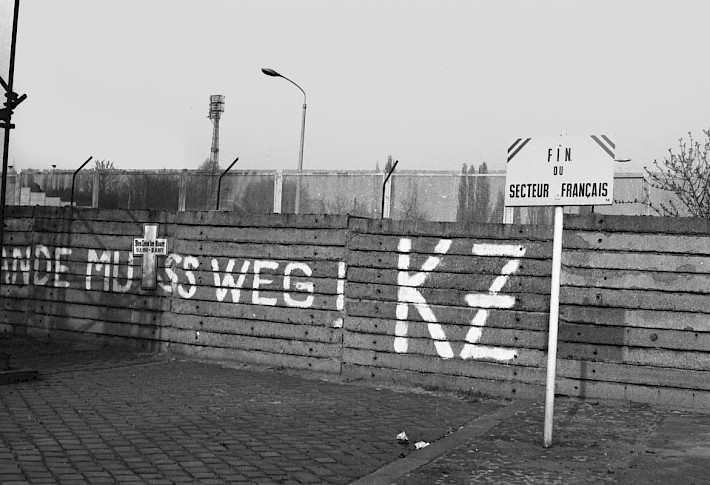 Berlin, ca. 1977 – Gedenkkreuz und Graffito an der Grenzmauer in der Bernauer Straße/Schwedter Straße (Fotograf: Detlef Machmüller)
