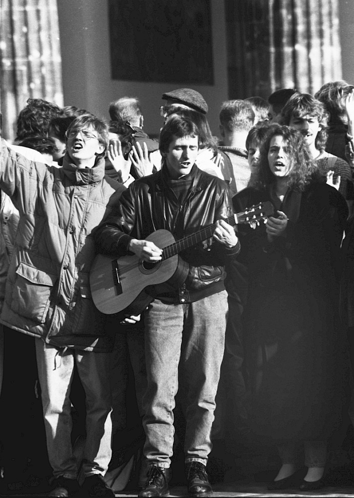 Berlin, 10. November 1989 – Gitarrenspieler und singende Menschen beim Mauerfall am Brandenburger Tor (Fotograf: Detlef Machmüller)