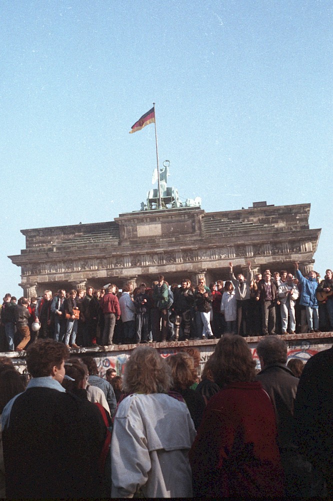 Berlin, 10. November 1989 – Feiernde Menschenmenge am Tag nach dem Mauerfall am Brandenburger Tor (Fotograf: Detlef Machmüller)