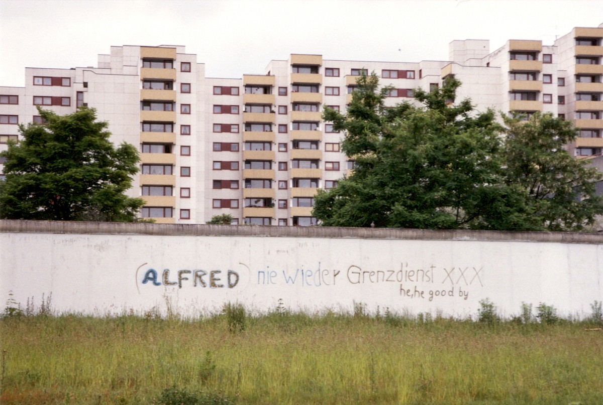 Berlin, April 1990 – Grenzmauer 75 mit Graffito von Grenzsoldaten östlich von Lichtenrade (Fotograf: Monika Waack)