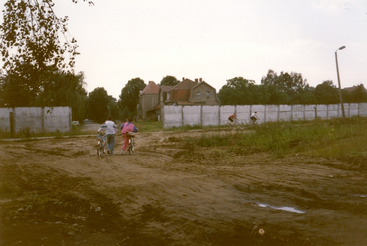 Berlin, Juni 1990 – Fahrradfahrer auf dem Weg zur offenen Hinterlandmauer vor der Siedlung Mahlow-Waldblick (Fotograf: Monika Waack)