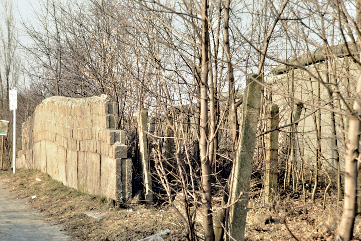 Berlin, ca. 1986 – Reste der alten Grenzmauer aus Hohlblocksteinen und Stacheldrahtzaun bei Lübars (Fotograf: Detlef Gallinge)