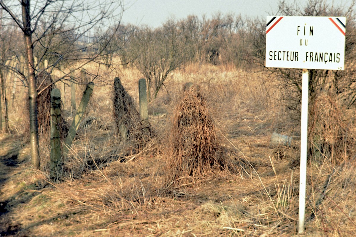 Berlin, ca. 1986 – Sektorenschild und Stacheldrahtzaun am Grenzstreifen bei Lübars (Fotograf: Detlef Gallinge)