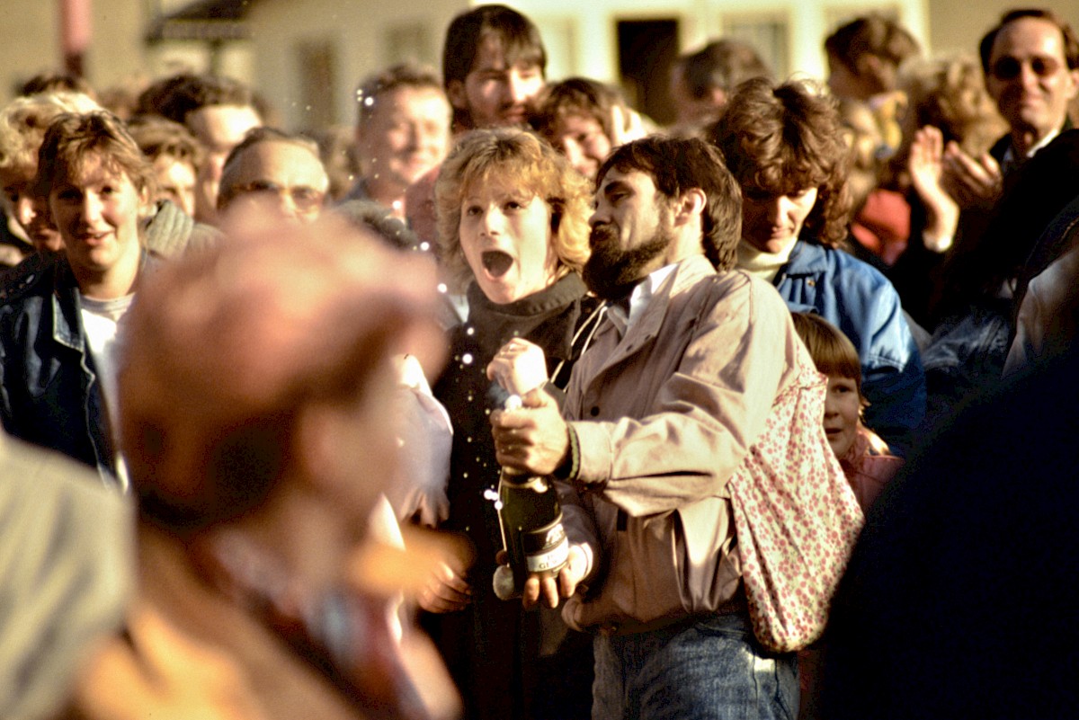 Berlin, 10. November 1989 – Zwei Personen lassen einen Sektkorken knallen an der Grenzübergangsstelle Invalidenstraße (Fotograf: Detlef Gallinge)