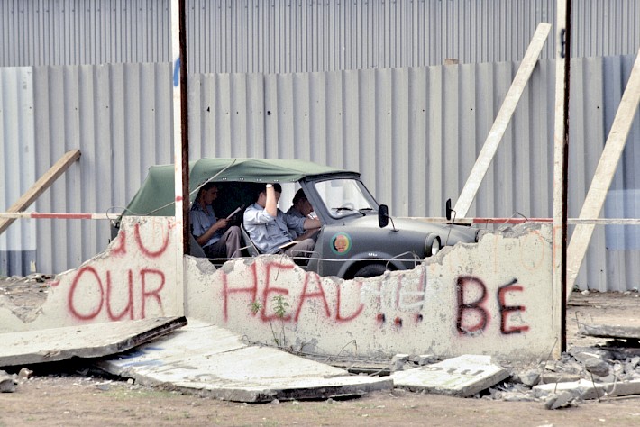 Berlin, 1990 – Kübelwagen Trabant mit Grenzsoldaten zwischen Resten der Hinterlandmauer (Fotograf: Detlef Gallinge)