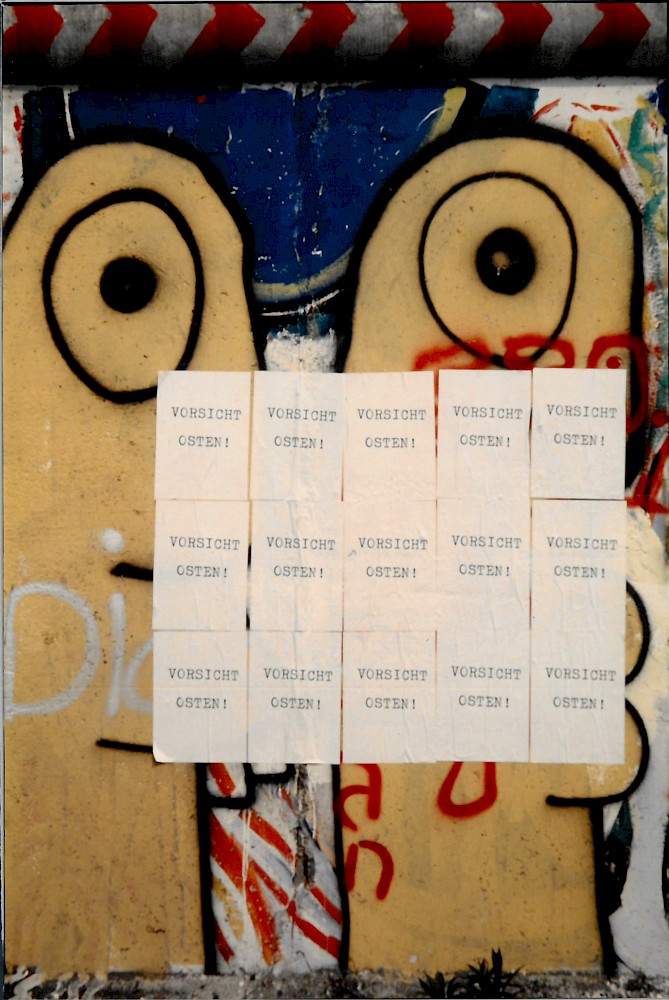 Berlin, ca. 1986 – Zwei Köpfe von Thierry Noir und Zettel an der Grenzmauer in Kreuzberg (Fotograf: Detlef Gallinge)