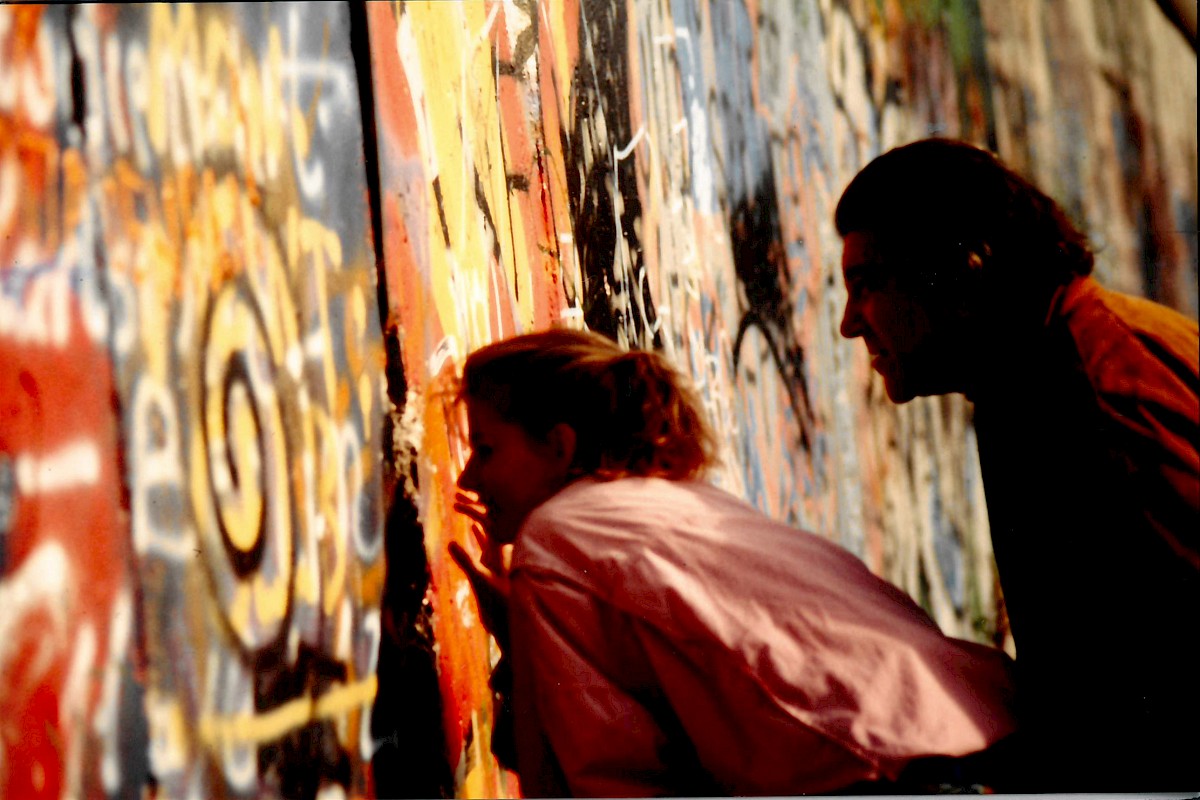 Berlin, November 1989 – Zwei Personen schauen durch eine Mauerlücke (Fotograf: Detlef Gallinge)