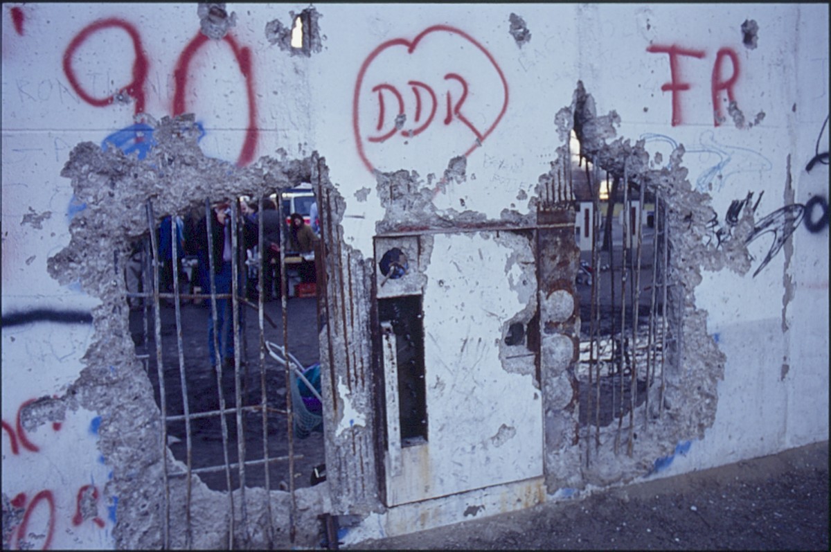 Berlin, Februar 1990 – Durchlöcherte Grenzmauer mit Graffiti hinter dem Reichstagsgebäude (Fotograf: Lothar Kruse)