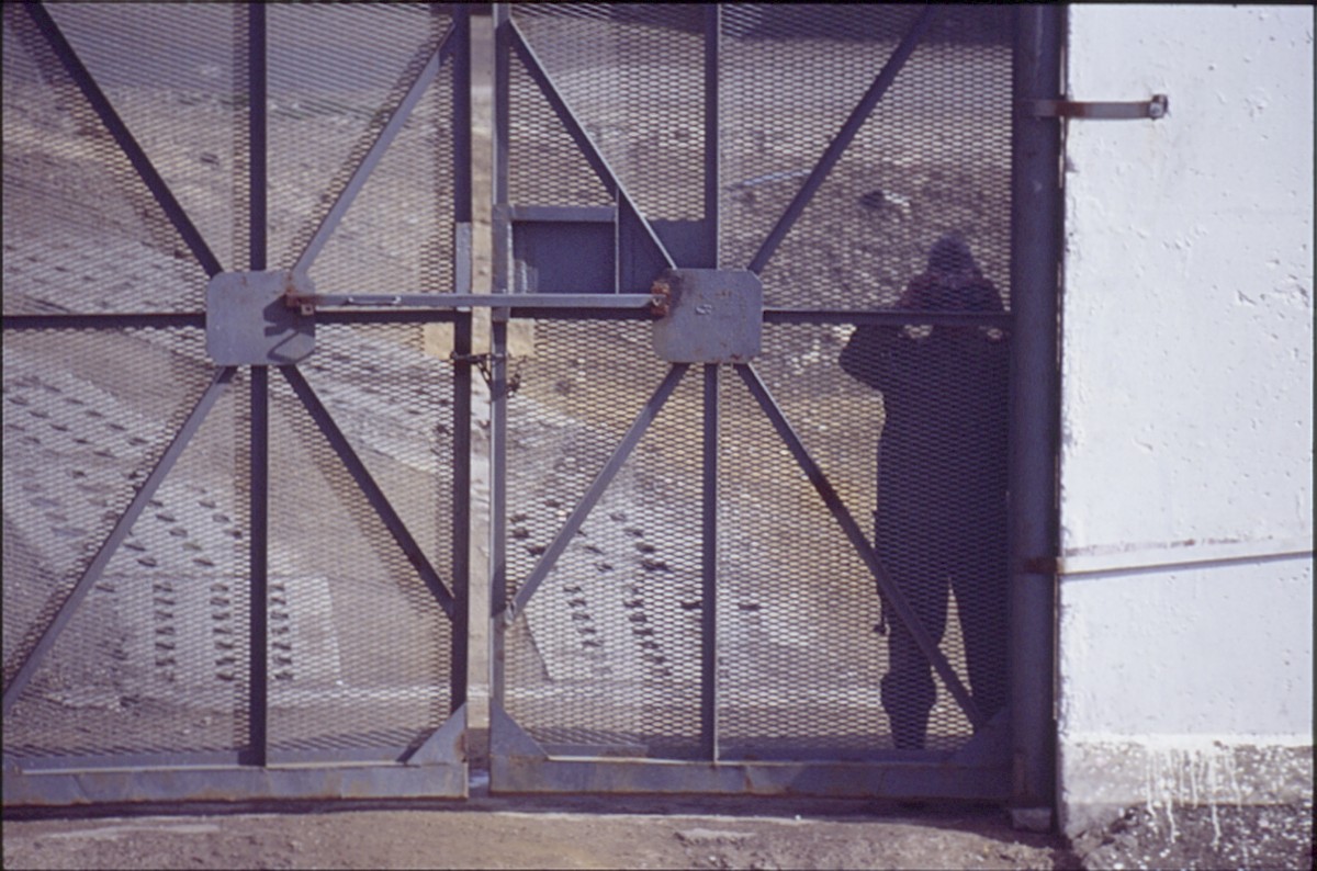 Berlin, 7. Oktober 1989 – Grenzsoldat hinter einem Zufahrtstor im Grenzstreifen an der Eberswalder Straße (Fotograf: Lothar Kruse)