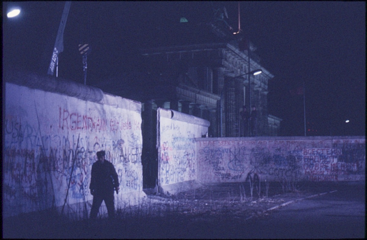 Berlin, 22. Dezember 1989 – Ein Grenzsoldat läuft vor der Mauer bei der Maueröffnung am Brandenburger Tor (Fotograf: Lothar Kruse)