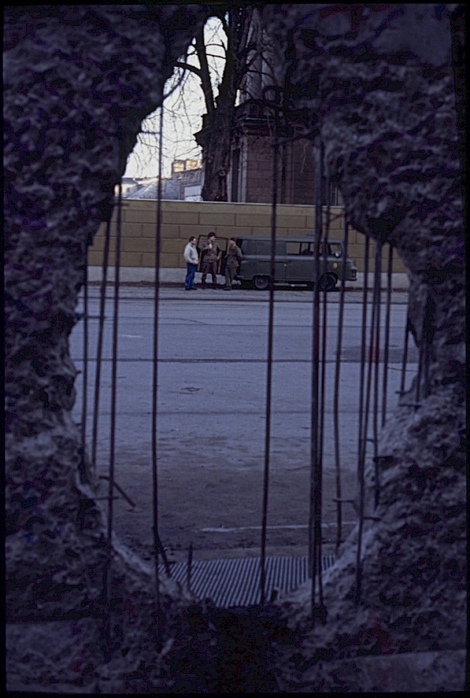 Berlin, Februar 1990 – Blick auf Grenzsoldaten durch ein Mauerloch (Fotograf: Lothar Kruse)
