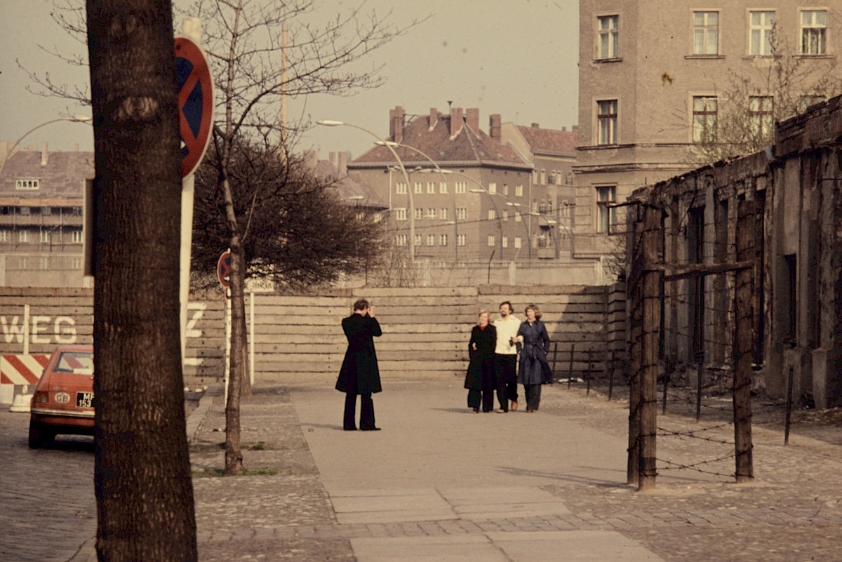 Berlin, März 1977 – Mauerbesucher fotografieren sich vor der Grenzmauer an der Bernauer Straße (Fotograf: Conrad Bicker)