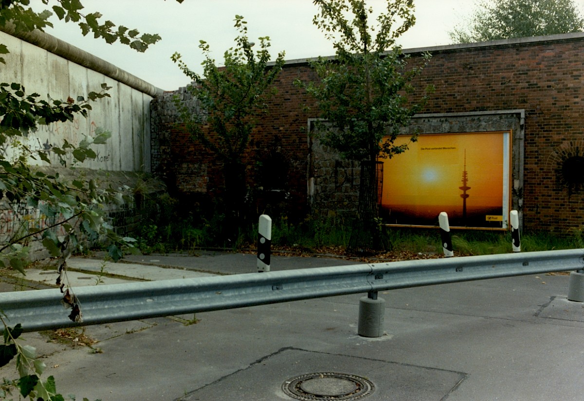 Berlin, ca. 1986 – Plakat und Grenzmauer am S-Bahnhof-Eingang Nordbahnhof (Fotograf: Harry Lange)