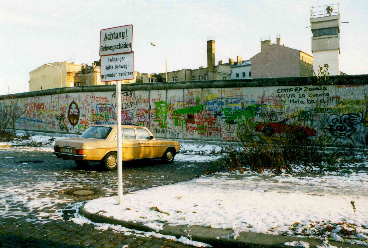 Berlin, 1988 – PKW an der mit Graffiti versehenen Grenzmauer 75 an der Bernauer Straße (Fotograf: Bourguignon)