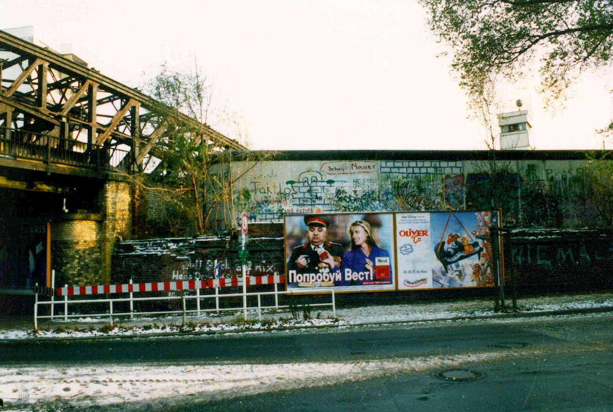 Berlin, 1989 – Grenzmauer 75 mit Graffiti und Reklame an der Liesenbrücke (Fotograf: Bourguignon)