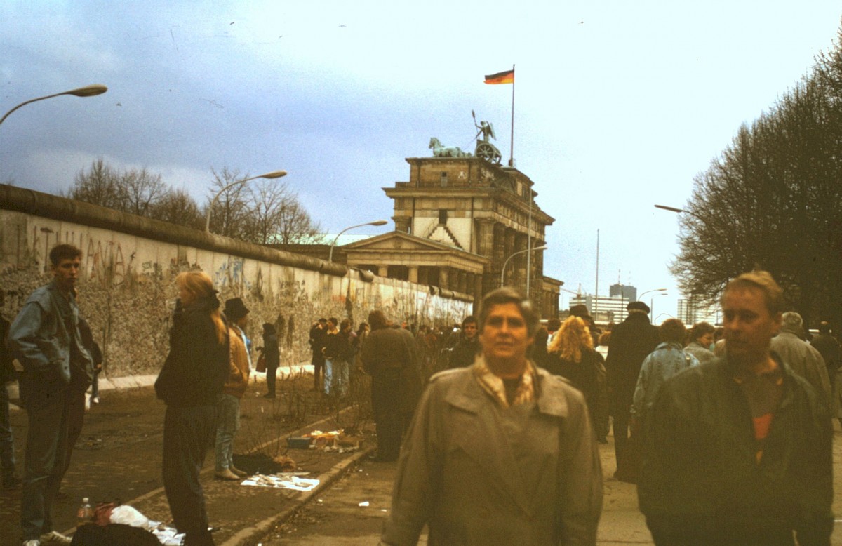 Berlin, 1990 – Passanten auf der West-Berliner Seite der Grenzmauer am Brandenburger Tor (Fotograf: )