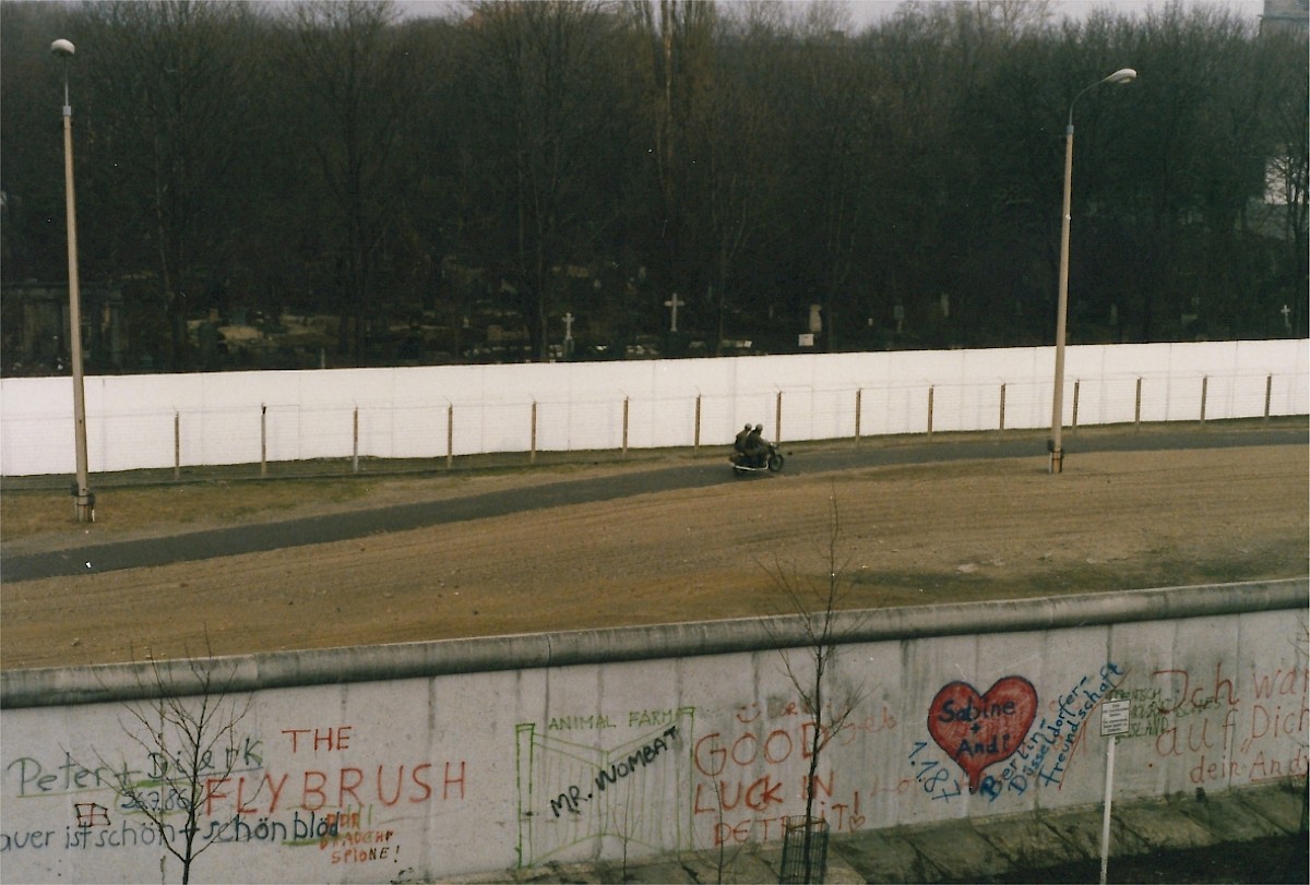 Berlin, ca. 1986 – Grenzsoldaten auf einem Motorrad im Grenzstreifen an der Bernauer Straße (Fotograf: )